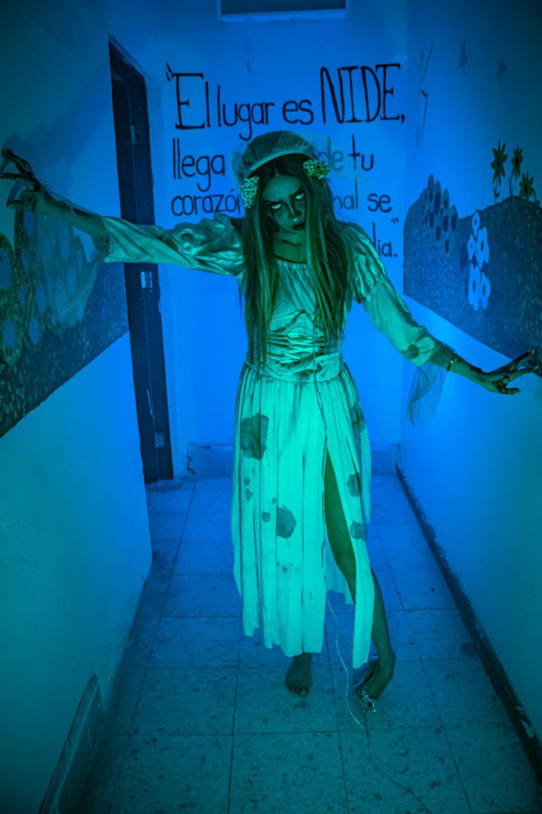 Ghost-like figure in eerie corridor, blue light, Ciudad de México ambiance.