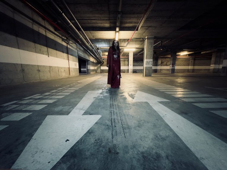 Creepy apparition in a dim parking garage setting. Perfect for horror themes.